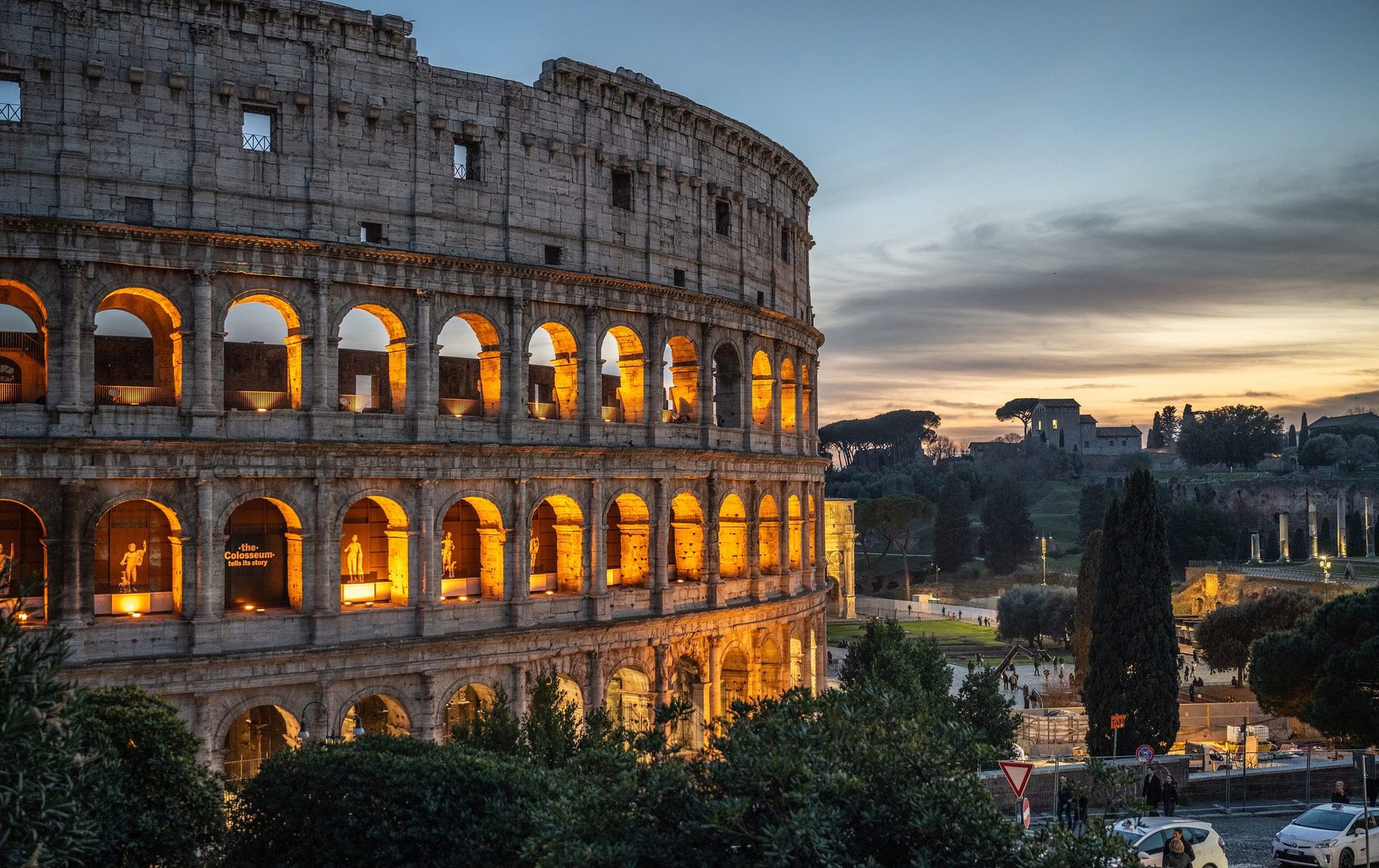 The arcades of the Colosseum lit at dusk